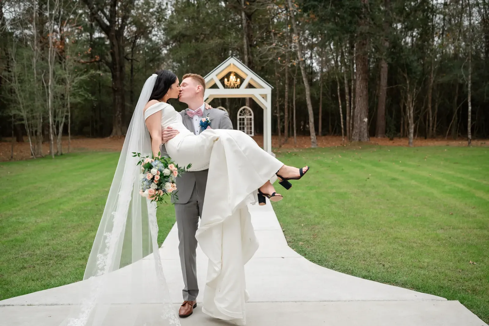 Groom carrying bride at chapel