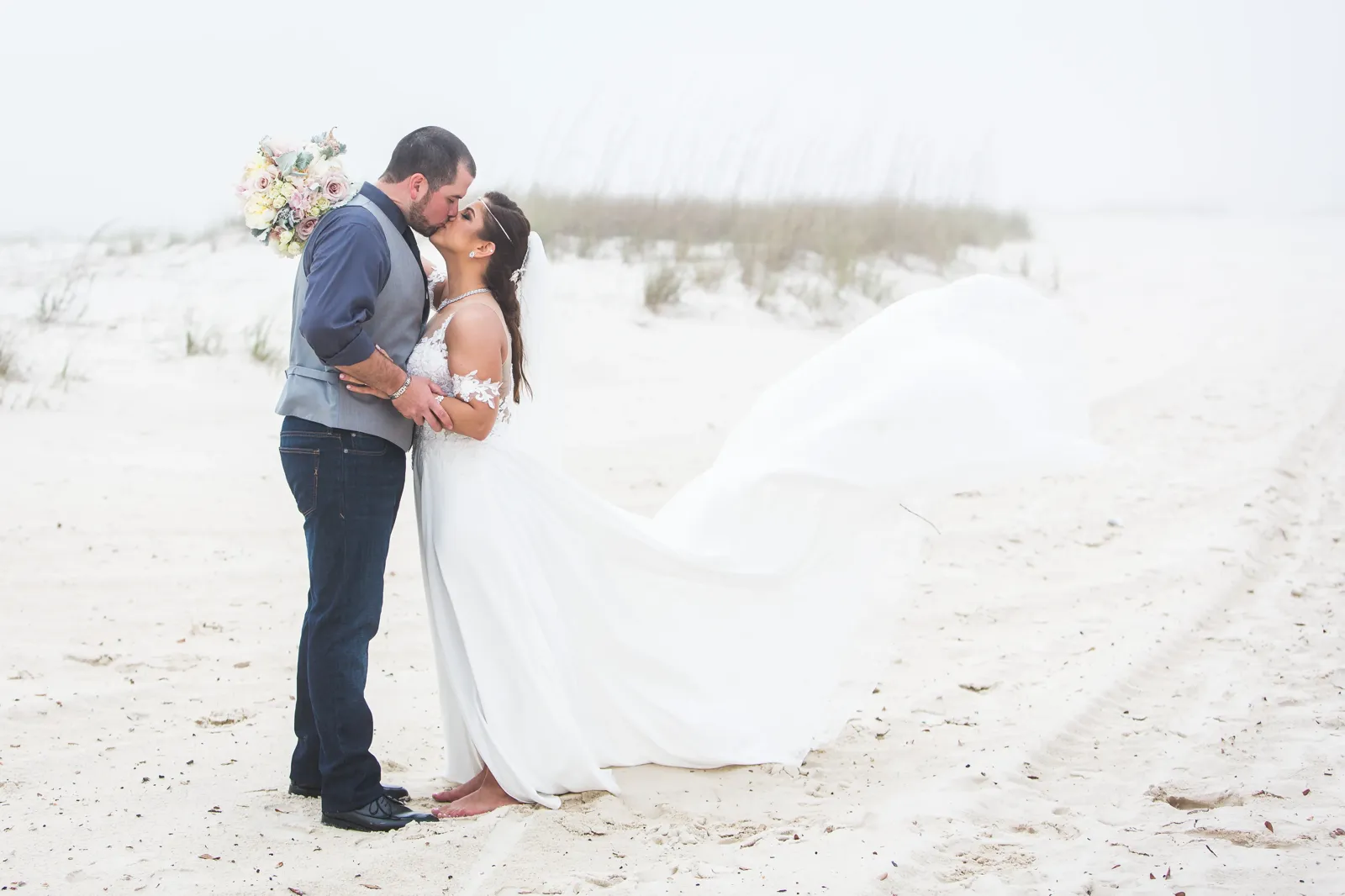 Beach kiss with flowing dress in wind